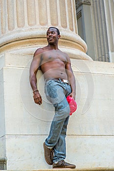 Young black man standing outsides in New York City in hot summer, relaxing