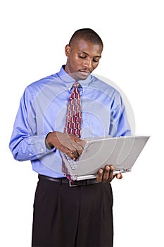 Young black man standing and working on laptop