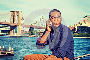 Young black man talking on cell phone outdoors in New York City