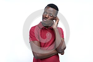 A young black man with a thoughtful expression, scratching his h photo