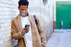 Young black man using his smartphone outdoors.