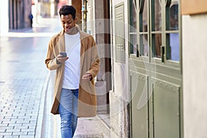 Young black man using his smartphone outdoors.