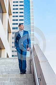 Young black man walking down stairs outside office building in New York City