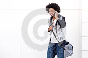 Young black man walking and talking on mobile phone