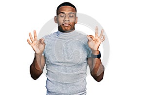 Young black man wearing casual t shirt relaxed and smiling with eyes closed doing meditation gesture with fingers