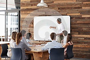 Young black man at whiteboard giving a business presentation