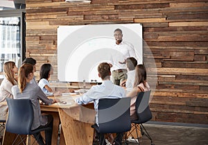 Young black man at whiteboard giving a business presentation photo