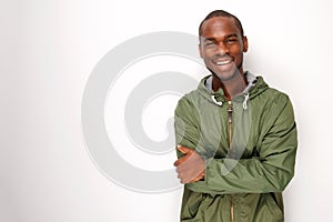Young black man with windbreaker jacket smiling against white background photo