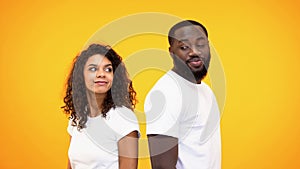 Young black man and woman looking each other standing back to back, affection photo