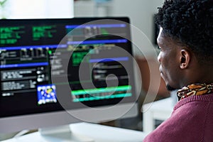 Young Black Man Working on Computer Programming Code in Office Setting