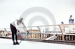 Young black sportsman exercising with elastic rubber bands in London.