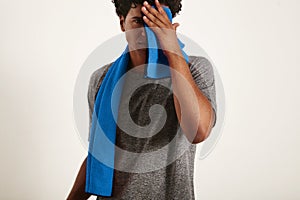 Young black sportsman wiping his face with a towel