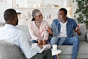 Young Black Spouses Having Relationship Problems, Sitting At Therapy Session With Counselor