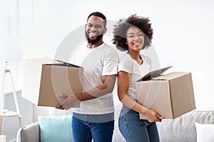 Young Black Spouses Posing Holding Packed Moving Boxes Standing Indoors