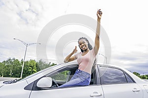 Young black teenage driver seated in her new car
