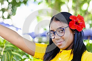 Young black woman 20-25 years old happy, with red flower in her hair