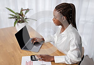 Young black woman accountant working at office, high angle view