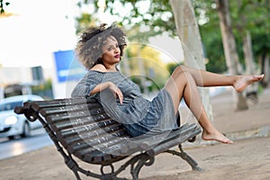 Young black woman with afro hairstyle smiling in urban background