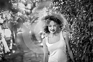 Young black woman with afro hairstyle smiling in urban park