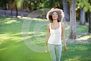 Young black woman with afro hairstyle smiling in urban park