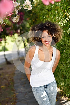 Young black woman with afro hairstyle smiling in urban park