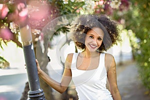 Young black woman with afro hairstyle smiling in urban park