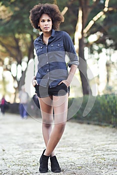 Young black woman with afro hairstyle standing in urban background