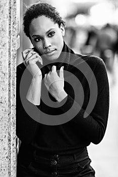 Young black woman with afro hairstyle standing in urban background