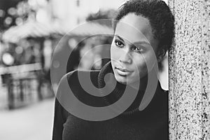 Young black woman with afro hairstyle standing in urban background