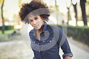 Young black woman with afro hairstyle standing in urban background