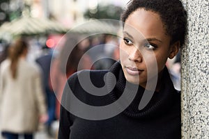 Young black woman with afro hairstyle standing in urban background