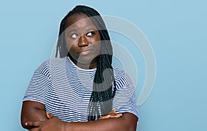 Young black woman with braids wearing casual clothes smiling looking to the side and staring away thinking