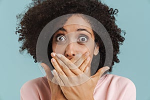 Young black woman covering her mouth while expressing surprise