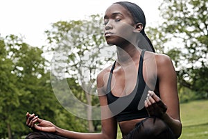 Young black woman doing meditation and yoga in a park