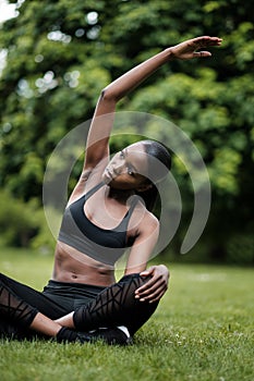 Young black woman doing meditation and yoga in a park