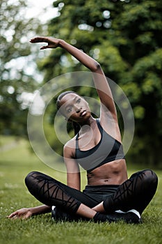 Young black woman doing meditation and yoga in a park