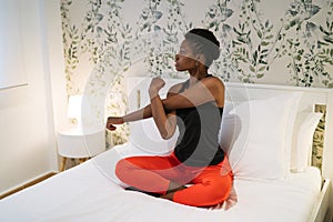 young black woman doing stretching exercise in bed