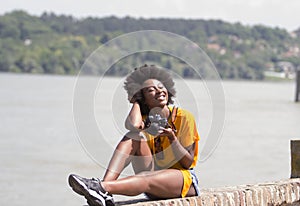 Young black woman with her eyes closed.She is enjoying a sunny day.