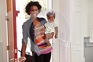 Young black woman holding child arriving home