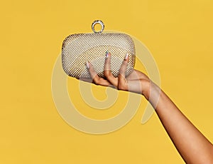 Young black woman holding a stylish gold metallic pochette