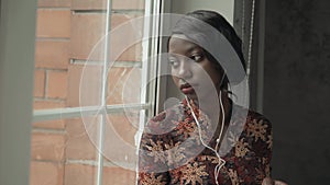 Young black woman listening music travelling looking outdoor the window, pensive - thoughtful, thinking future, music