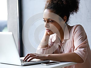 Young black woman looking at laptop