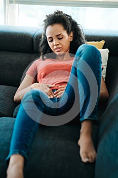 Young Black Woman With Menstrual Pain Lying On Sofa