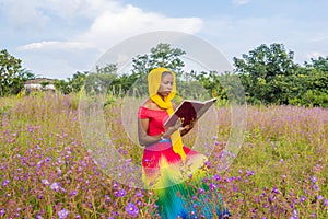 young black woman reading a textbook while sitting alone outdoor