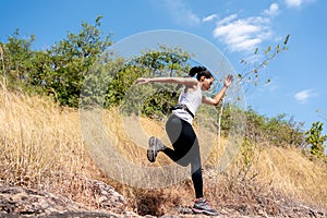 Young Black Woman Running and  Jumping at Forest Trail