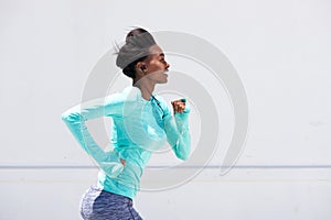 Young black woman running outside with earphones photo