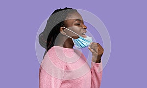 Young Black Woman Taking Off Protective Medical Mask, Can Not Breathe