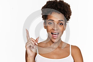 Young black woman in tank top exclaiming and pointing finger upward