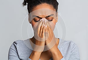 Young black woman touching her nose bridge