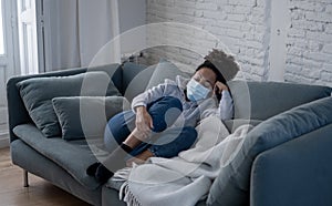 Young black woman wearing protective mask against COVID virus suffering from depression